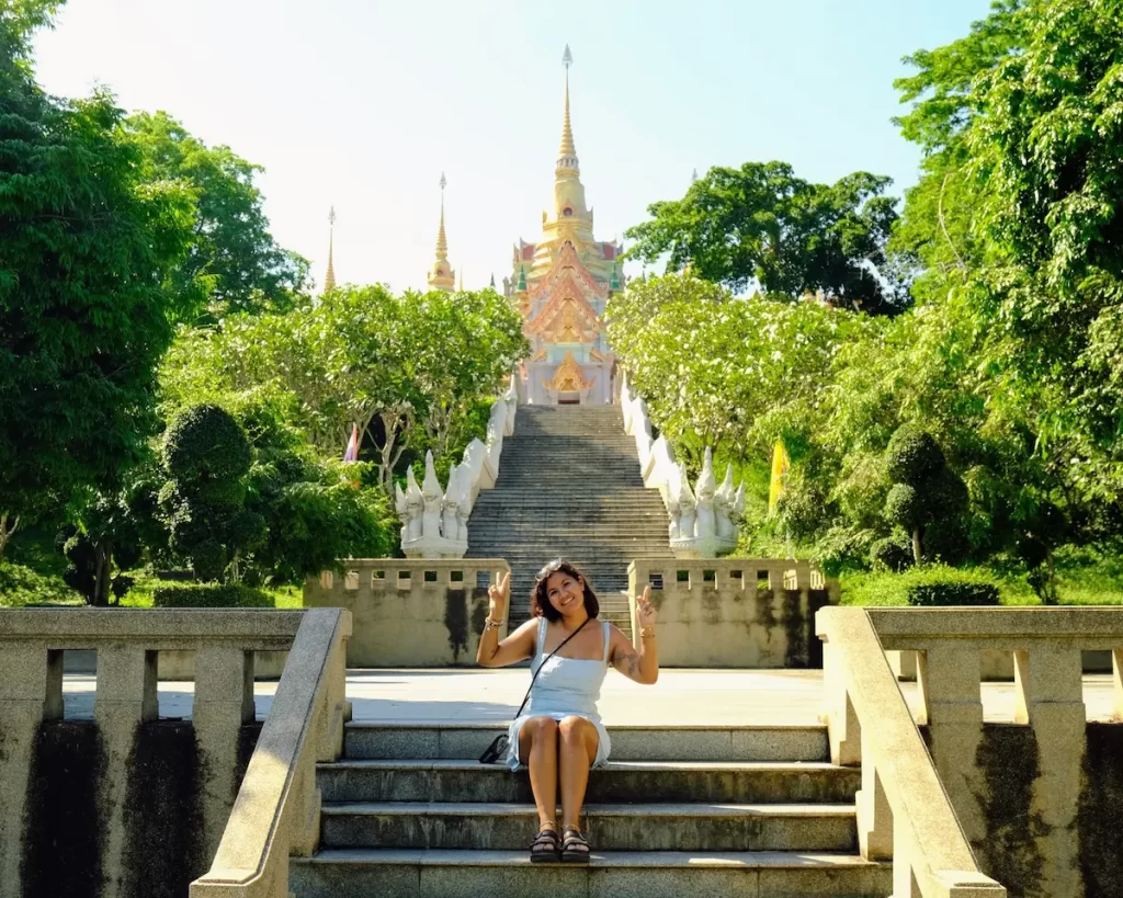 Sonia sitting outside a temple in Thailand during a slower style of travel experience